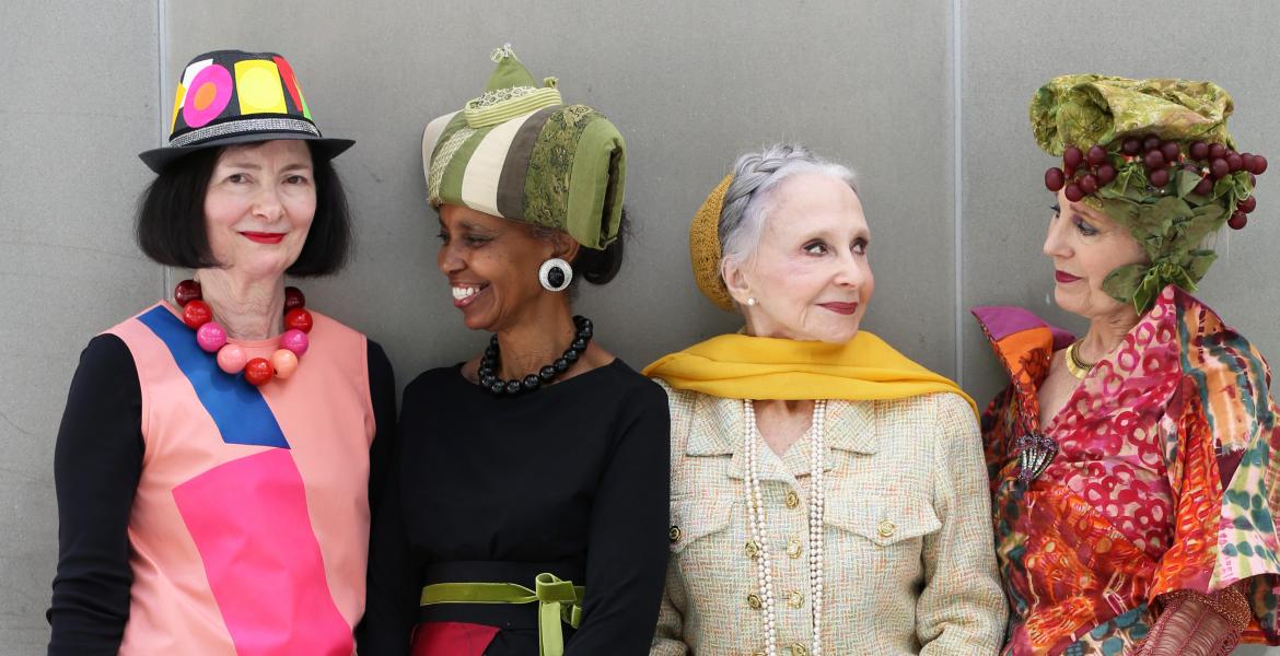 Group of 4 stylish, colorfully-dressed women smiling